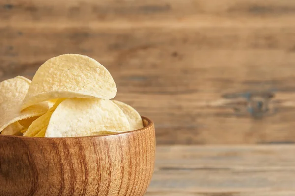 Crispy potato chips in wooden bowl. Salted potato chips. — Stock Photo, Image