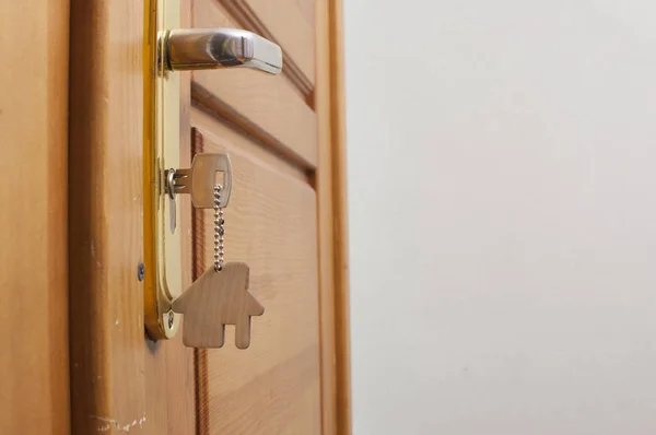 Una chiave in una serratura con l'icona della casa sopra — Foto Stock