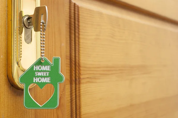 Uma chave em uma fechadura com ícone de casa nele — Fotografia de Stock