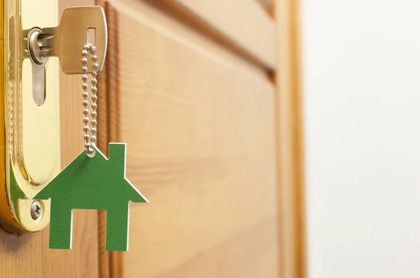 Uma chave em uma fechadura com ícone de casa nele — Fotografia de Stock