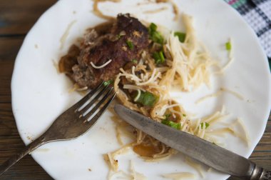ahşap bir arka plan üzerinde bir tabak üzerinde makarna ile pirzola 