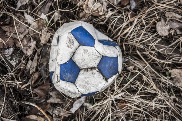 Vieja bola de fútbol de cuero desgarrado azul y blanco — Foto de Stock