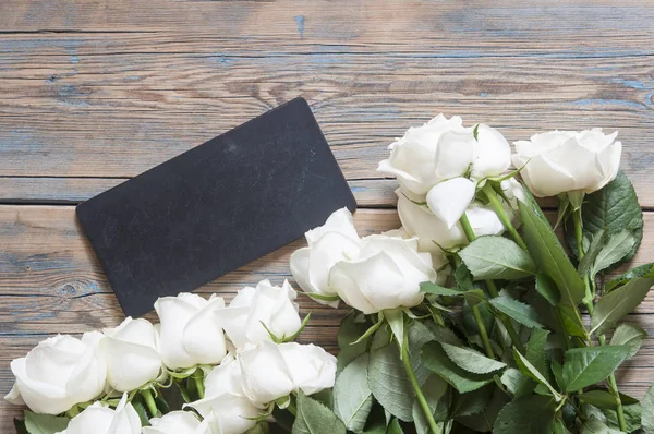 Eski Beyaz ahşap masa üzerinde beyaz güller