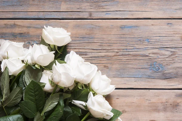 Rosas blancas sobre una vieja mesa de madera blanca — Foto de Stock