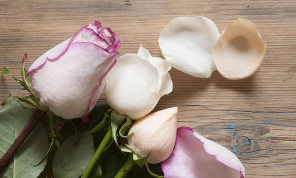 Buquê de rosas sobre mesa de madeira . — Fotografia de Stock