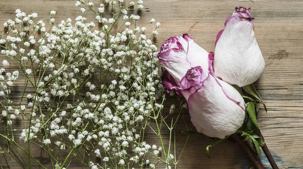 Ramo de rosas sobre mesa de madera . — Foto de Stock