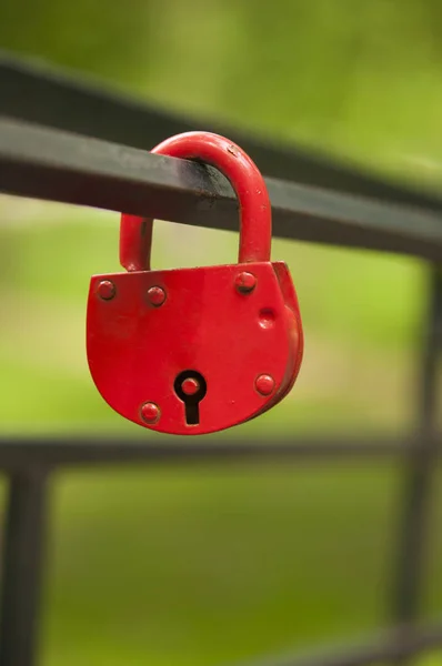 Red padlock in the shape of a heart, on a metal pipe — Stock Photo, Image