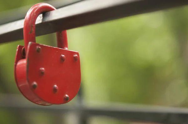 Red padlock in the shape of a heart, on a metal pipe — Stock Photo, Image