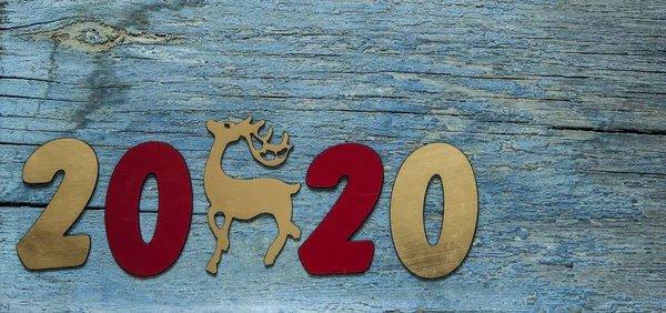 New year concept. Digits 2020 on wooden background with Christma