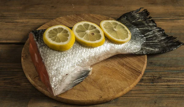 Rabo de salmão com limão e sal marinho na mesa de madeira — Fotografia de Stock