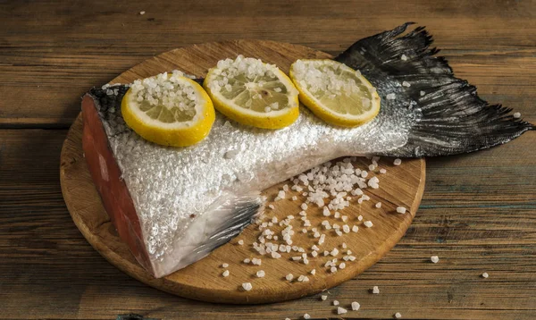 Rabo de salmão com limão e sal marinho na mesa de madeira — Fotografia de Stock