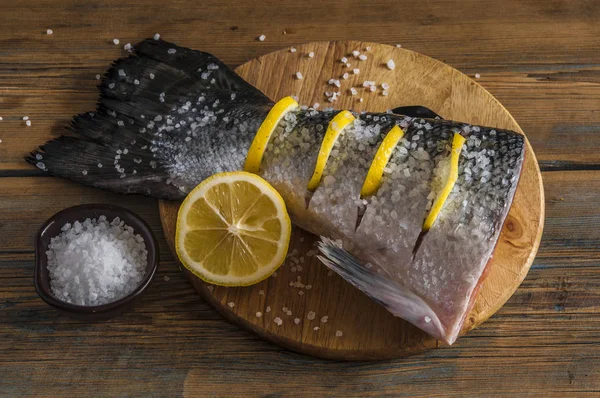Ουρά σολομού με λεμόνι και θαλασσινό αλάτι σε ξύλινο τραπέζι — Φωτογραφία Αρχείου