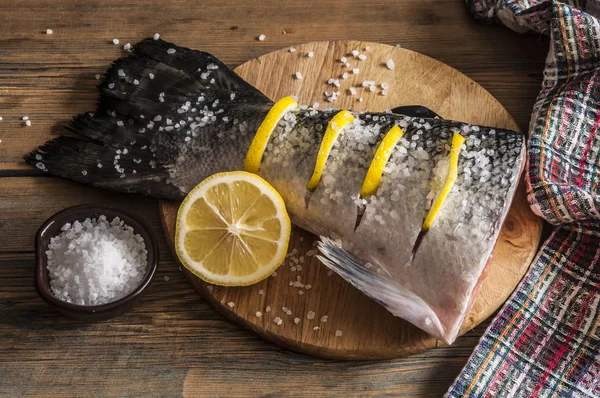Хвост лосося с лимоном и морской солью на деревянном столе — стоковое фото
