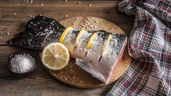 Coda di salmone con limone e sale marino sulla tavola di legno — Foto Stock