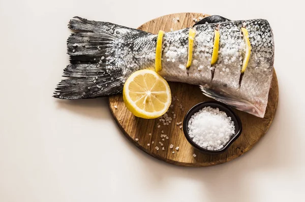 Rabo de salmão fresco com sal marinho e limão sobre fundo branco — Fotografia de Stock