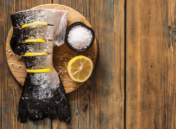 Rabo de salmão com limão e sal marinho na mesa de madeira — Fotografia de Stock