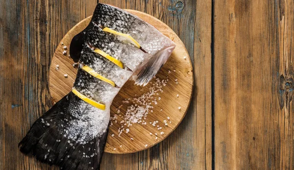 Rabo de salmão com limão e sal marinho na mesa de madeira — Fotografia de Stock