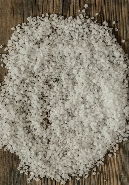 Hromada jedlé mořské soli s velkými krystaly na hnědé dřevěné ba — Stock fotografie