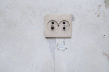 Duvarda eski beyaz elektrik soketi.