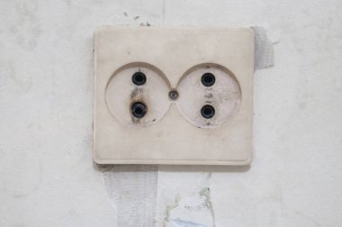 Duvarda eski beyaz elektrik soketi.