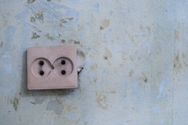 Duvarda eski beyaz elektrik soketi.