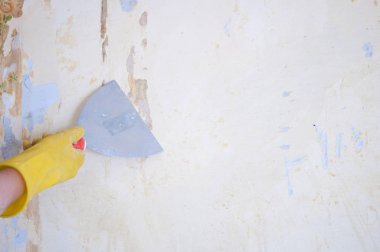 bir spatula ile el Duvar Kağıdı duvar temizler