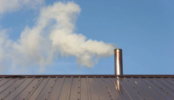 Smoke coming out the chimney against sky