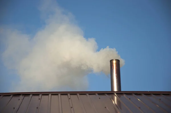 Smoke coming out the chimney against sky