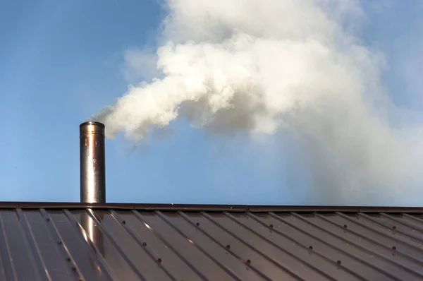 Smoke coming out the chimney against sky