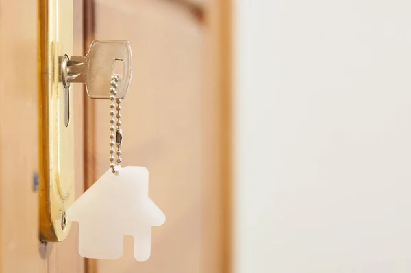 Una llave en una cerradura con icono de la casa en ella — Foto de Stock