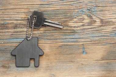 House ile ahşap üzerine gümüş anahtar taşı sembolü. Emlak kavramı
