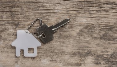 House ile ahşap üzerine gümüş anahtar taşı sembolü. Emlak kavramı