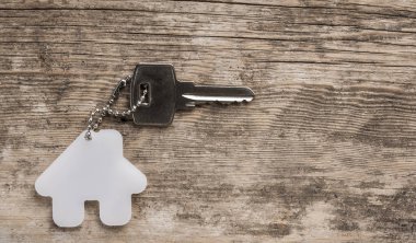 House ile ahşap üzerine gümüş anahtar taşı sembolü. Emlak kavramı
