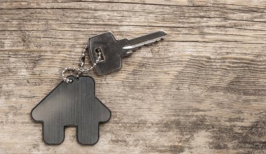 House ile ahşap üzerine gümüş anahtar taşı sembolü. Emlak kavramı