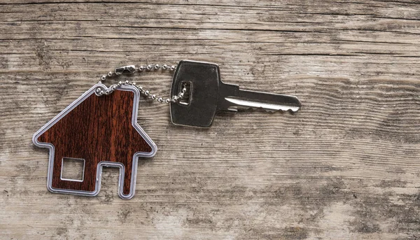 House ile ahşap üzerine gümüş anahtar taşı sembolü. Emlak kavramı