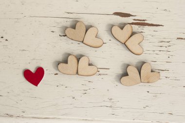 Kırmızı kalp ve beyaz ahşap arka plan üzerinde birçok ahşap kalpler.
