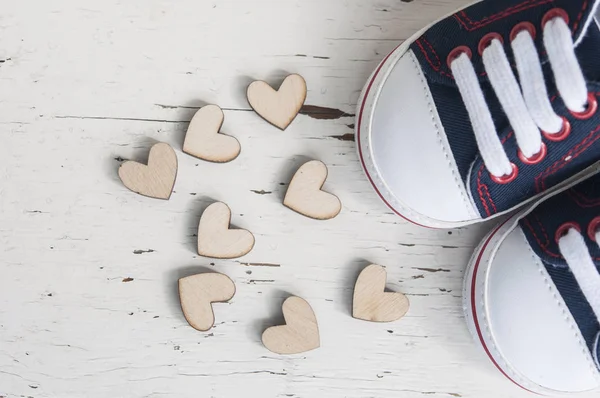 Kleurrijke canvas schoenen of sneakers voor kinderen of baby voet en hout — Stockfoto