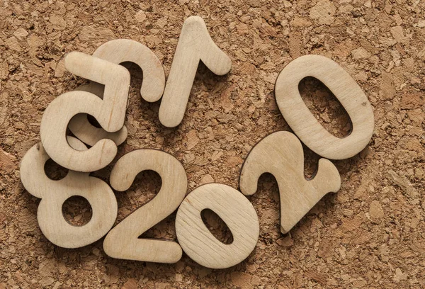 Щасливий фон Нового 2020 року з безліччю цифр на корковому фоні — стокове фото