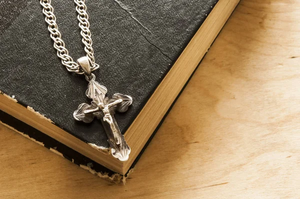 Heilige Bijbel met zilveren kruis op houten achtergrond — Stockfoto