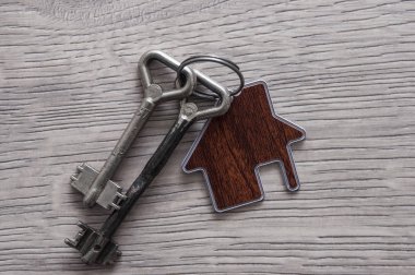 Ev anahtarı kalp şeklinde, anahtarlık ahşap arka planda, c