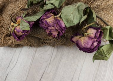 Soyut gül buketi, ahşap masa üzerinde eski çuval desenli kurutulmuş çiçek buketi.