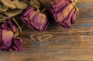 Sınır olarak eski ahşap zemin üzerinde pembe kurumuş güller yığını.