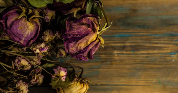 Sınır olarak eski ahşap zemin üzerinde pembe kurumuş güller yığını.