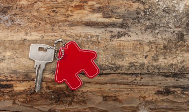 Ev anahtarlığı, ahşap döşeme tahtalarına dayanan ev anahtarı, eve taşınma ya da kiralık mülk konsepti.