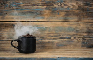 Sıcak kahve ve duman ahşap arka planda