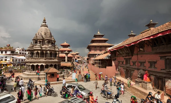 KATHMANDU, NEPAL - Yağmurlu bir günde Patan Durbar Meydanı 'ndan geçen insanlar. Katmandu Vadisi 'ndeki üç Durbar Meydanı' ndan ve UNESCO Dünya Mirasları Alanından biridir..