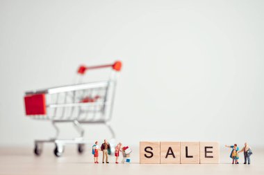 Satılık minyatür alışveriş önünde imzala. Perakende kavramı.