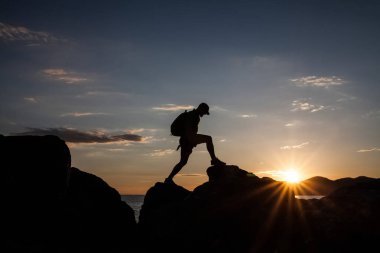 Siluet dağda günbatımında hiking bir gezgin. Özgürlük, risk, meydan okuma, başarı kavramı.