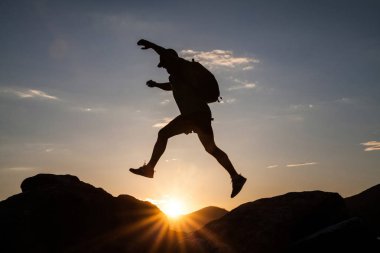 Siluet dağda günbatımında hiking bir gezgin. Özgürlük, risk, meydan okuma, başarı kavramı.
