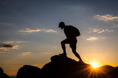 Siluet dağda günbatımında hiking bir gezgin. Özgürlük, risk, meydan okuma, başarı kavramı.